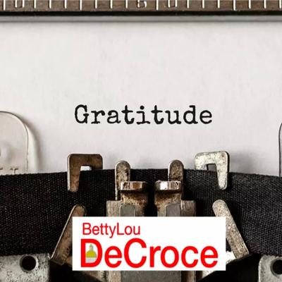 Typewriter writing the word "Gratitude" with BettyLou DeCroce's logo at the bottom